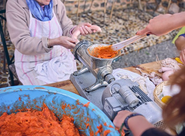 Personas haciendo chorizos en la matanza del cerdo. Suministros La Ronda.